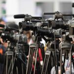 TV cameras lined up, covering large public event