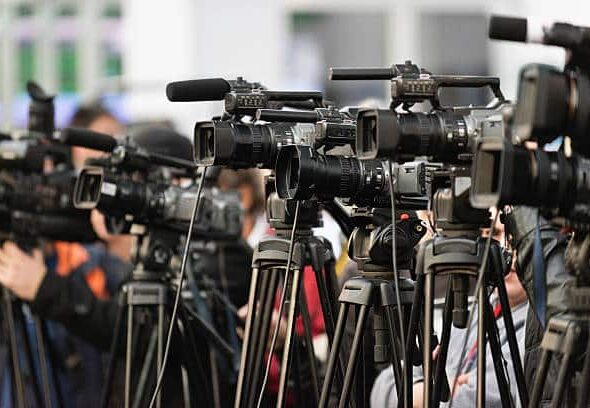TV cameras lined up, covering large public event